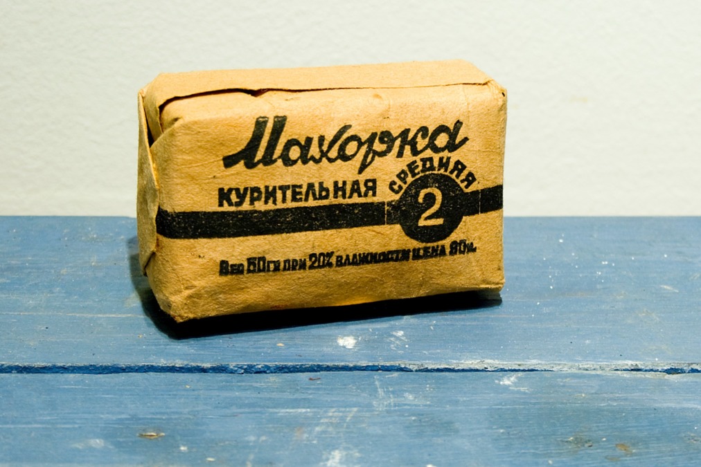 Keltasävyinen pakkaus, jossa venäjänkielistä tekstiä, sinisellä pöydällä Degerby Igor-museossa.